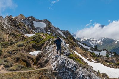 Man walking on rock against sky