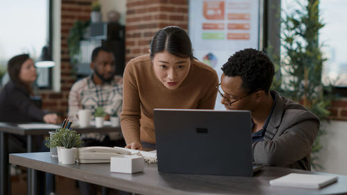 Side view of man using laptop while sitting at office