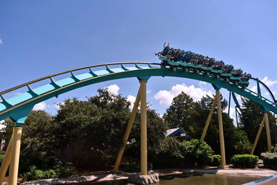 Low angle view of chain swing ride against clear blue sky