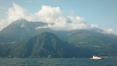 Boats in sea with mountains in background