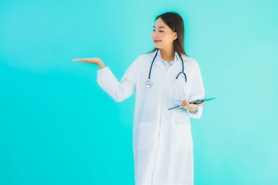 Woman standing against blue background