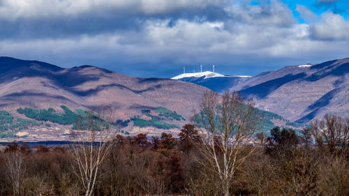 Scenic view of mountains and windmills against sky