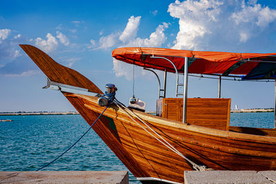 Sailboat moored on sea against sky