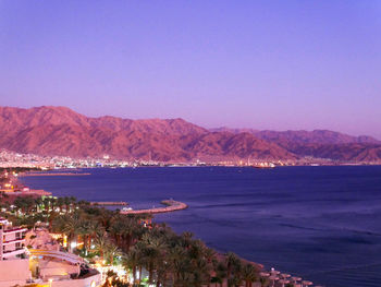 Scenic view of sea and mountains against clear sky