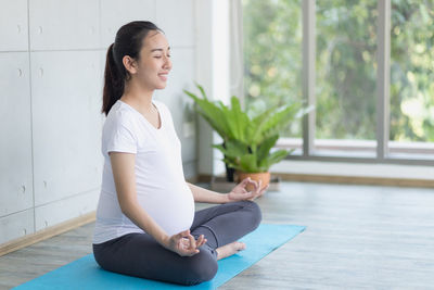 Full length of woman sitting on floor