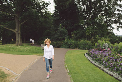 Full length of woman walking on footpath in park
