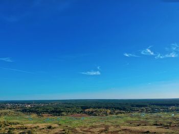 Scenic view of field against blue sky