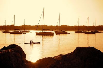 Silhouette sailboats on sea against sky during sunset