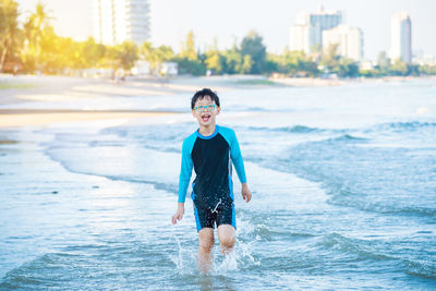 Boy enjoying in sea on shore at beach