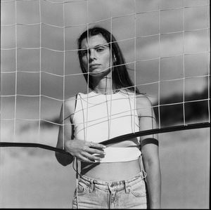 Portrait of young woman standing against wall