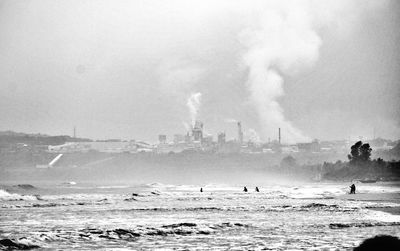 Panoramic view of people on beach against sky