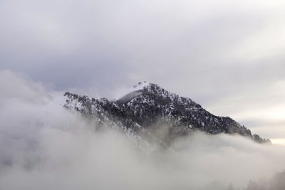 Low angle view of snow covered mountain against sky