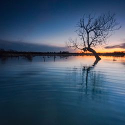 Scenic view of lake against sky at sunset