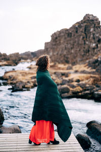 Rear view of woman looking at sea against sky