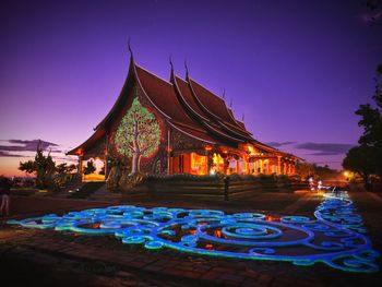 Illuminated temple against blue sky at night