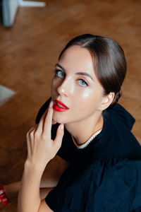 Close-up of young woman applying lipstick