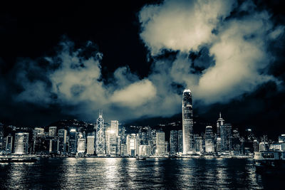 Illuminated buildings in city against sky at night