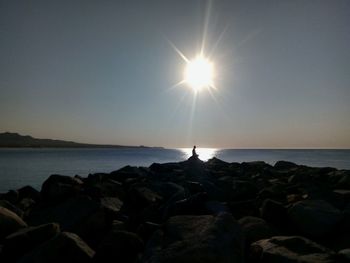 Scenic view of rocks in sea against clear sky