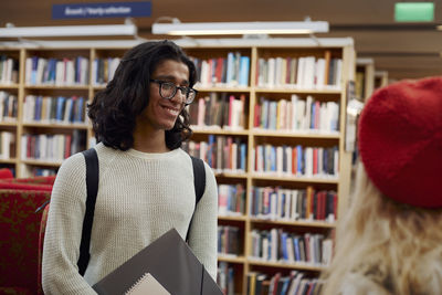 Two students talking in library