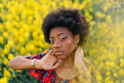 Portrait of young woman with yellow flower