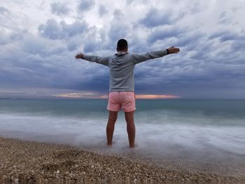 Full length rear view of man standing on beach