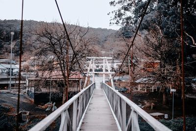 Footbridge amidst trees during winter