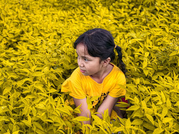 High angle view of boy on yellow flowering plants