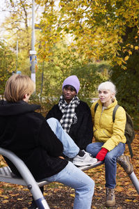 Three friends in park in autumn scenery