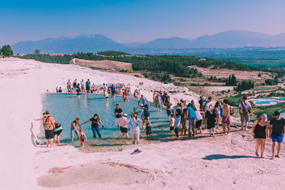 People at beach against sky