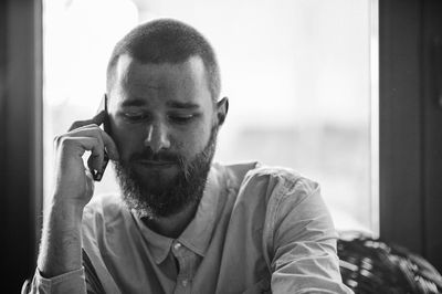 Close-up of young man using smart phone at home