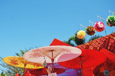 Low angle view of multi colored flower tree against clear blue sky