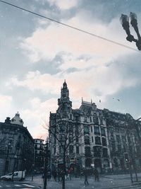 Buildings in city against cloudy sky