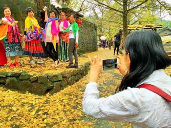 Midsection of woman photographing multi colored umbrella