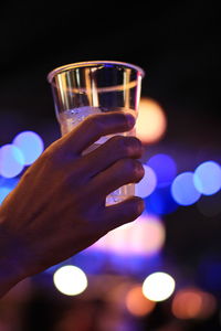 Close-up of hand holding drink against blurred background