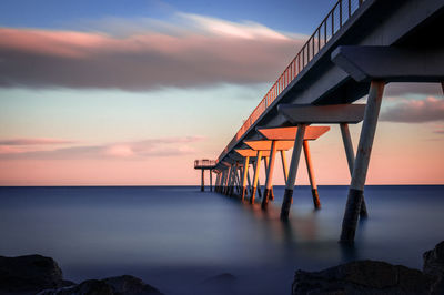 Lifeguard hut on sea against sky during sunset