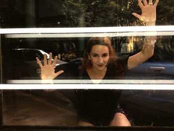 Portrait of young woman in glass window