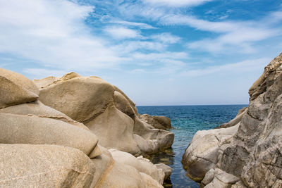 Scenic view of rocks on beach against sky