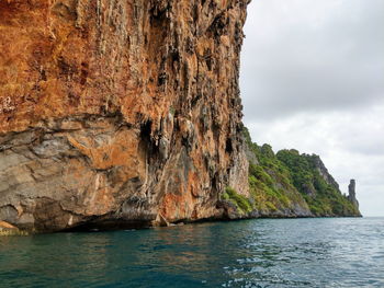 Rock formations by sea against sky