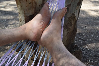 Low section of man resting on hammock