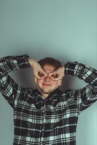 Portrait of young man standing against wall