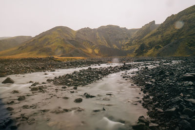 Scenic view of sea and mountains against sky