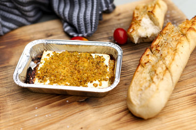 Chopping board with baguette and grilled cheese