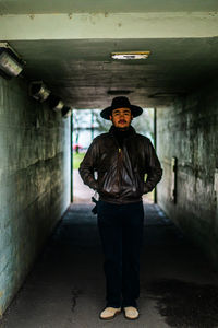 Portrait of man standing in illuminated tunnel