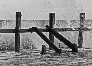 Close-up of railing on beach against sky