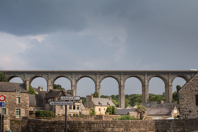 Low angle view of arch bridge against cloudy sky