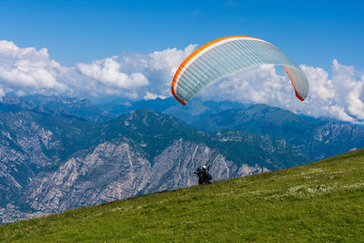 Low angle view of person paragliding against mountain