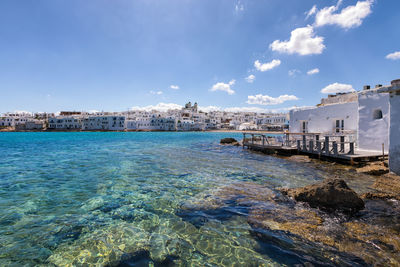 Scenic view of sea by buildings against sky