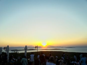 People at beach during sunset