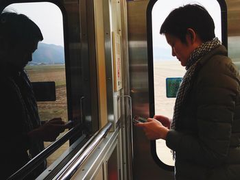 Woman using mobile phone in train