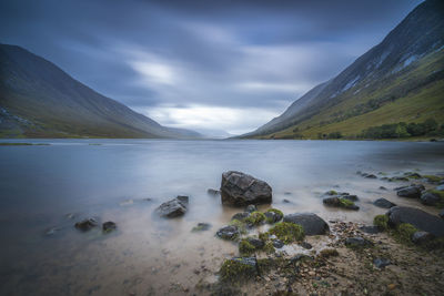 Scenic view of sea loch and mountains against cloudy sky